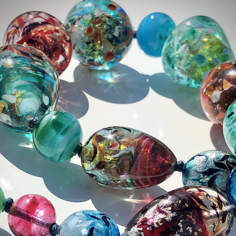 The necklace is made with Murano glass beads, is handmade and unique. The beads are made using the "Perle Sommerso" technique, which consists of submerging coloured beads to create a multi layered effect. 